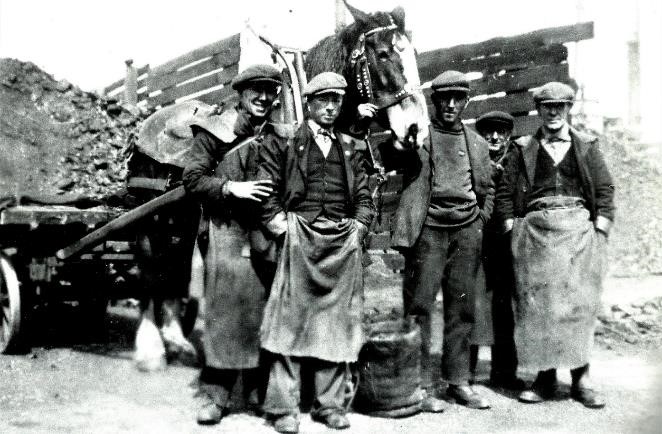 Fred Curragh, far left, with his workmates in 1946, was employed by ‘John Kelly Ltd, Coal Merchants and Steamship Owners’ who had premises at Station Street and Scrabo Street, Queen’s Quay, not far from the Belfast & County Down Railway headquarters. Once upon a time coal made the world go around. Until modern times it was the primary form of energy used to heat homes and provided power for factories, ships and steam locomotives. 